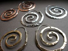 "These swirl hoops are hand pound, shaped and polished. Hand made ear wires are sterling silver. Great for every day. The texture and hand forged quality catches the light and give these simple earrings dimension. High quality craftsmanship, but light weight. Available in solid copper, bronze or sterling silver. Ancient spiral meaning: Evolution, Life, Consciousness, Creation Size: Medium 1 7/8\" H x 1 5/8 \" W Finish: Satin finish is a matte brushed finish. High shine is polished to a brilliant Handmade Spiral Sterling Silver Wrap Earrings, Unique Spiral Nickel-free Hoop Earrings, Unique Nickel-free Spiral Hoop Earrings, Unique Hand Forged Spiral Earrings, Swirl Shaped Nickel-free Hoop Earrings As Gift, Nickel-free Swirl Hoop Earrings Gift, Swirl Hoop Earrings Nickel Free Gift, Hammered Spiral Sterling Silver Jewelry, Hammered Sterling Silver Spiral Jewelry