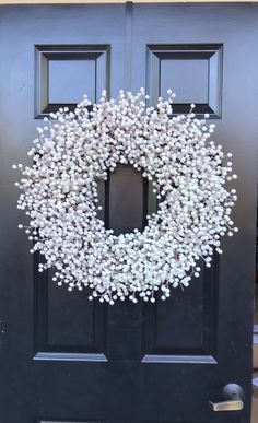 a black door with a white wreath on it