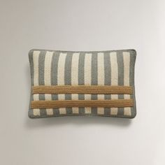 a gray and white striped pillow sitting on top of a table