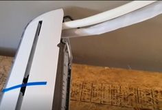 the back end of a white refrigerator with blue tape on it's handle and bottom part