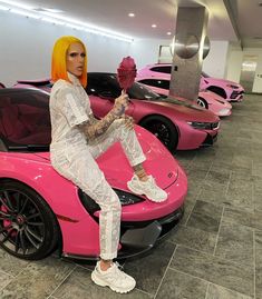 a woman sitting on top of a pink car