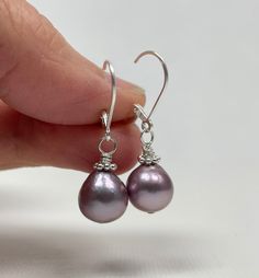 Lavender Pearl Earrings. Sterling Silver Leverback Earrings. The earrings are handmade using Edison freshwater pearls (nucleated) and sterling silver components. These gorgeous pearls are lavender in color with great luster and silvery to pink overtones. The pearls are natures' creations and are little differences are seen in color and shape; they are a short teardrop shape and ~9.3 mm wide. The earrings, accented by sterling silver Bali daisies and mounted with simple leverback earring wires, measure 1 1/4 inches (3.1 cm) long. Pearl is a June birthstone. Pictures are enlarged to show detail. You will receive a remake of these beautiful lavender Edison pearl precious metal leverback earrings made with the same quality materials and attention to detail. The earrings ship in a small organza Elegant Lavender Earrings With Ear Wire, Lavender Teardrop Earrings With Ear Wire, Teardrop Pearl Earrings With Lever Back For Gift, Handmade Teardrop Pearl Earrings For Anniversary, Gift Pearl Drop Earrings With Lever Back, Purple Hook Earrings For Anniversary, Purple Earrings With Ear Wire For Anniversary, Purple Anniversary Earrings With Ear Wire, Lavender Teardrop Jewelry With Ear Wire