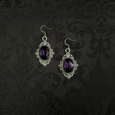 "These richly detailed earrings are made with antiqued silver tone settings. Their captivating design is accented with dark amethyst purple glass jewels.  Earrings measure 2\" in length (including stainless steel hooks) and 1\" wide.  Matching chokers are listed separately in our store. If you don't see items with a color you want, feel free to ask about availability." Dark Purple Jewelry Aesthetic, Black And Purple Vampire Aesthetic, Purple And Black Earrings, Purple Accessories Jewelry, Purple And Black Jewelry, Purple Prom Accessories, Gothic Metal Jewelry With Antique Finish, Medieval Silver Jewelry For Halloween, Gothic Metal Jewelry With Filigree