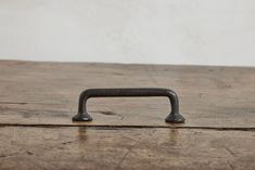 an old wooden table with a metal handle