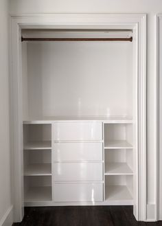 an empty white closet with shelves and drawers