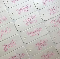 several tags with pink ink on white paper