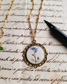 a close up of a necklace on a piece of paper with a pen next to it