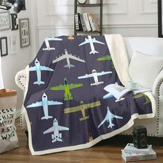 a living room with a couch and a blanket on the floor that has airplanes all over it