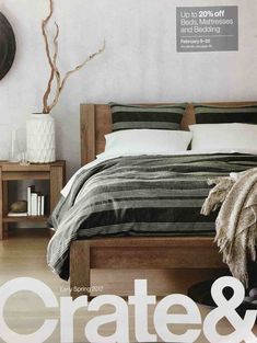 the cover of crate & barrel magazine features a bed with black and white striped bedspread