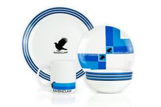 a blue and white dinnerware set with a black bird on the plate next to it