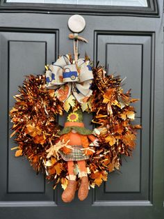 a wreath on the front door is decorated with autumn leaves and a scarecrow doll