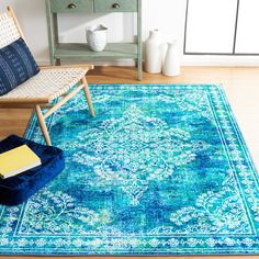 a blue area rug in a living room with a chair and side table on the floor