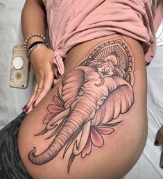 an elephant tattoo on the side of a woman's thigh