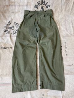 Handmade, one of a kind pants made using a Korean war era US military sleeping bag. Inspired by vintage riding pants, these have a barrel shaped leg silhouette and the option to become tapered at the ankles by adjusting the button strap. Have a double reinforced seat and a small front pocket. I put two 1940s-1950s "Howe Military Academy Riding Camp" felt patches on the front. Lightweight cotton poplin material. Please note there are areas of light staining, discoloration, and small distressed ar Military Parachute Pants With Hip Pockets, Military Style Parachute Trousers For Outdoor, Military Style Khaki Parachute Trousers, Military Style Wide Leg Khaki Parachute Pants, Military Style Khaki Wide Leg Parachute Pants, Military Style Wide Leg Bottoms For Outdoor, Military Style Wide Leg Parachute Pants For Outdoor, Military Wide Leg Parachute Pants For Outdoor, Vintage Cargo Pants With Cargo Pockets For Outdoor