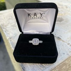 an engagement ring in a velvet box on a table with the name kay jewelry written on it