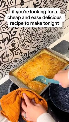 someone is cooking food on the stove with a spatula in their hand and an orange towel