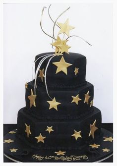 a three tiered cake with gold stars on it