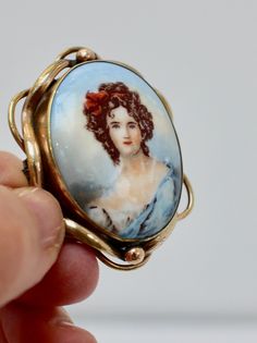 Pinchbeck Painted Cameo Brooch Details ~  Super antique brooch with hand painted porcelain portrait, depicting a lovelyl 19th century lady in blue, her hair in ringlets tied up in a red ribbon.  It has a rather grand pinchbeck setting which is typical of the traditional Victorian brooch, and has a bar and C clasp fastening. c 1850s. It would make a super gift, for a birthday or just a treat! Measures ~  5cm X 4cm  ( approx 2" x 1.5" in inches) Condition ~  Good vintage condition. Thank you for your interest Please read the shop policies before purchasing as they contain important information about payment and shipping to help you Victorian Style Enamel Pin Gift, Victorian Style Wedding Brooch Enamel Pin, Victorian Wedding Enamel Brooch Pin, Victorian Style Wedding Enamel Brooch Pin, Victorian Brooch, Vintage Givenchy, Glitter Crafts, Faux Pearl Earrings, Super Gifts