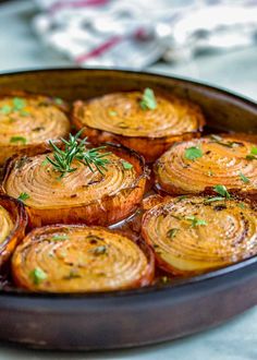 baked potatoes with herbs in a pan on a white counter top, ready to be eaten