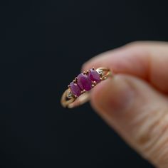 Get ready to make a statement with this stunning handmade, vintage trilogy ring crafted from high-quality 10k yellow gold. This ring boasts three magnificent pinkish red rubies and two dazzling accent diamonds that will take your breath away. The center stone measures 5.5mm x 3mm, while the two stones on either side measure 4.5mm x 3mm, all held securely in place by elegant prongs. The split shank design at the top of the ring leads down to a straight shank, ensuring a comfortable and snug fit o Ruby Trilogy Ring, Three Stone Ring Design, Heirloom Three Stone Ruby And Diamond Ring, Heirloom Three Stone Ruby Ring With Diamonds, Heirloom Three-stone Ruby Ring With Diamonds, Heirloom Three-stone Ruby And Diamond Ring, Red Three-stone Diamond Ring For Anniversary, Classic Three-stone Ruby Ring, Classic Three Stone Ruby Ring