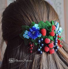 a close up of a woman's hair with berries and flowers on it