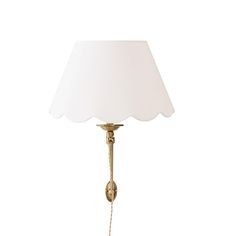 a lamp that has a white shade on it and is attached to a wall or ceiling