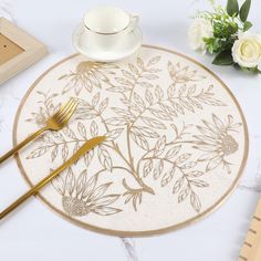 there is a place mat with flowers on it and a fork next to the plate