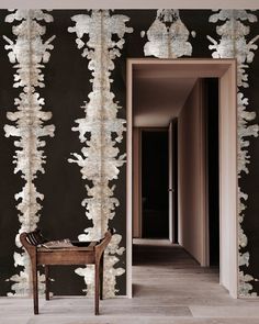 a chair sitting in front of a black wall with white paint on it's walls