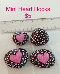 three rocks with pink and black hearts on them