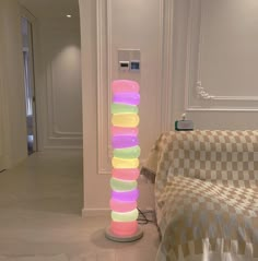 a large stack of colored balls sitting on top of a floor next to a couch