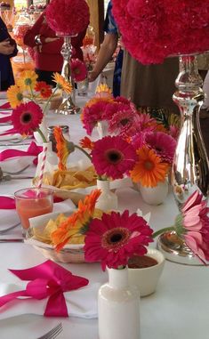 the table is set with pink and orange flowers