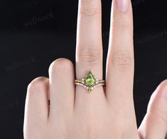 a woman's hand with a ring on it and a green stone in the middle