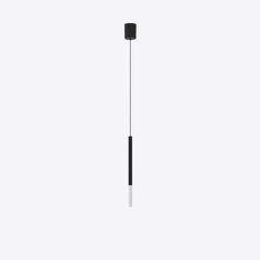 a black and white object is hanging from a long pole with a light on it