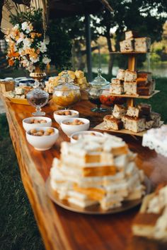 a wooden table topped with lots of desserts on top of it's sides