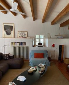 a living room filled with furniture and wooden beams