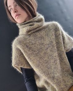 a woman wearing a sweater with a cowl neck