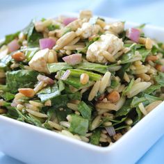 a white bowl filled with rice and veggies on top of a blue table cloth