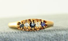 This is a wonderful 5 stone Sapphire and Diamond Ring.  It is in the classic Victorian style that presents the stones in such a beautiful way.  The ring is size 9 and can be sized by your local jeweler.   I like being able to offer rings in larger sizes for my customers.  It is in rich 18K gold and weighs 4.1 grams. Classic Multi-stone Sapphire Ring, Classic Multi-stone Birthstone Ring, Classic Multi-stone Sapphire Promise Ring, Classic Multi-stone Birthstone Ring For Anniversary, Heirloom Multi-stone Sapphire Ring, Classic Multi-stone Birthstone Ring For Wedding, Timeless Multi-stone Sapphire Ring For Wedding, Timeless Multi-stone Sapphire Wedding Ring, Heirloom Multi-stone Round Cut Birthstone Ring