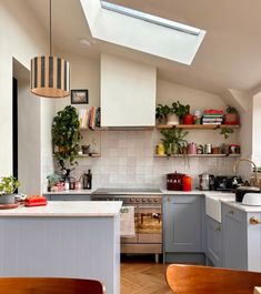 a kitchen filled with lots of counter space next to a stove top oven under a skylight