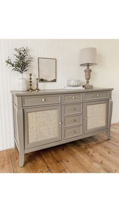 the sideboard is painted gray and has wicker panels on it's sides