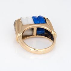 This is part of Chairish’s Fine Jewelry assortment.  Finely detailed mid century vintage cocktail ring (circa 1950s to 1960s), crafted in 14 karat yellow gold.   Fluted sodalite and white agate measures 12mm x 10mm. The diamonds total an estimated 0.15 carats (estimated at I colour and SI2 clarity). The sodalite and white agate are in excellent condition and free of cracks or crisps.  The fluted white agate and sodalite sit flush in the medium rise mount, with diamond details to the side shoulde Vintage Yellow Gold Enamel Ring With Gemstone, Vintage Multi-stone Sapphire Ring, Vintage Cocktail Ring, Vintage Diamond Rings, Gold Cocktail, White Agate, Vintage Cocktail, Mid Century Vintage, Ring Diamond