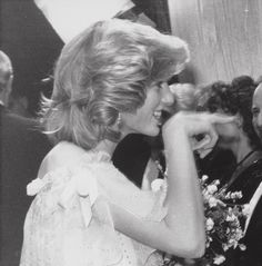 an old black and white photo of a woman in a dress talking on her cell phone