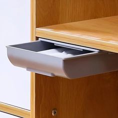 an open drawer on the side of a wooden cabinet with a paper holder in it