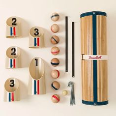 an assortment of wooden objects are displayed on a white surface, including balls and chopsticks