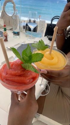 a person holding up a glass with some fruit in it