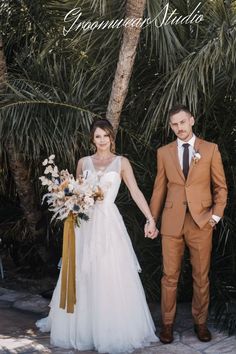 a bride and groom holding hands in front of palm trees