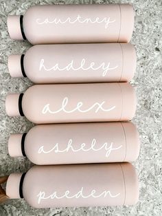 three pink bottles with white writing on them