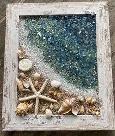 an old frame with shells and starfish on the beach