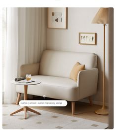 a white couch sitting next to a table with a glass cup on top of it