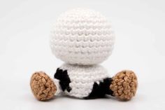 a crocheted stuffed animal sitting on top of a white table next to a black and white object